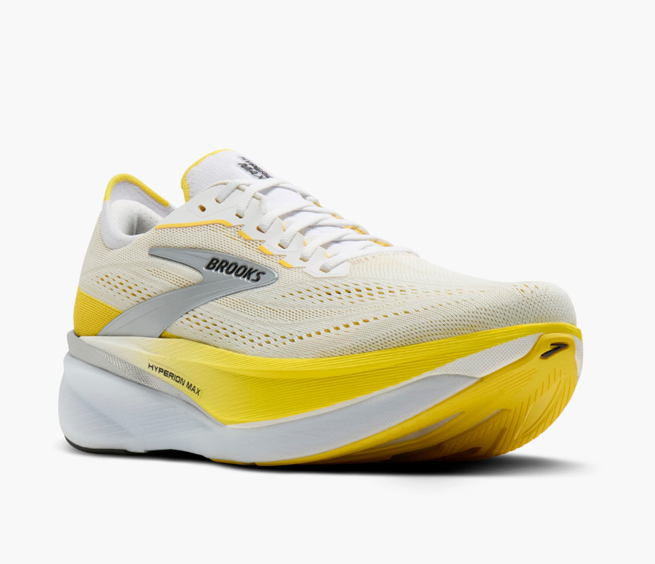 A white running shoe with yellow and gray accents, branded Brooks, featuring a large cushioned sole.