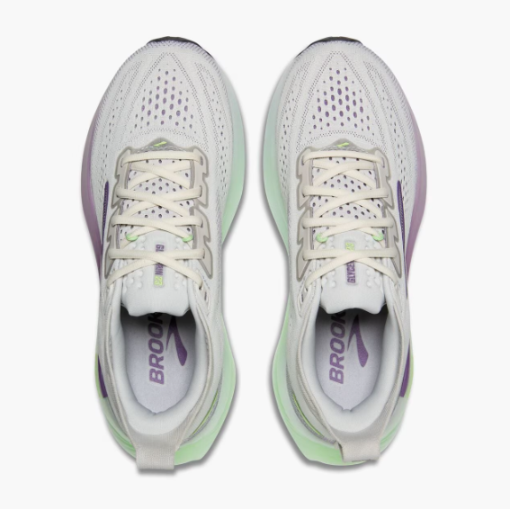 A pair of white athletic running shoes with purple and green accents, viewed from above.