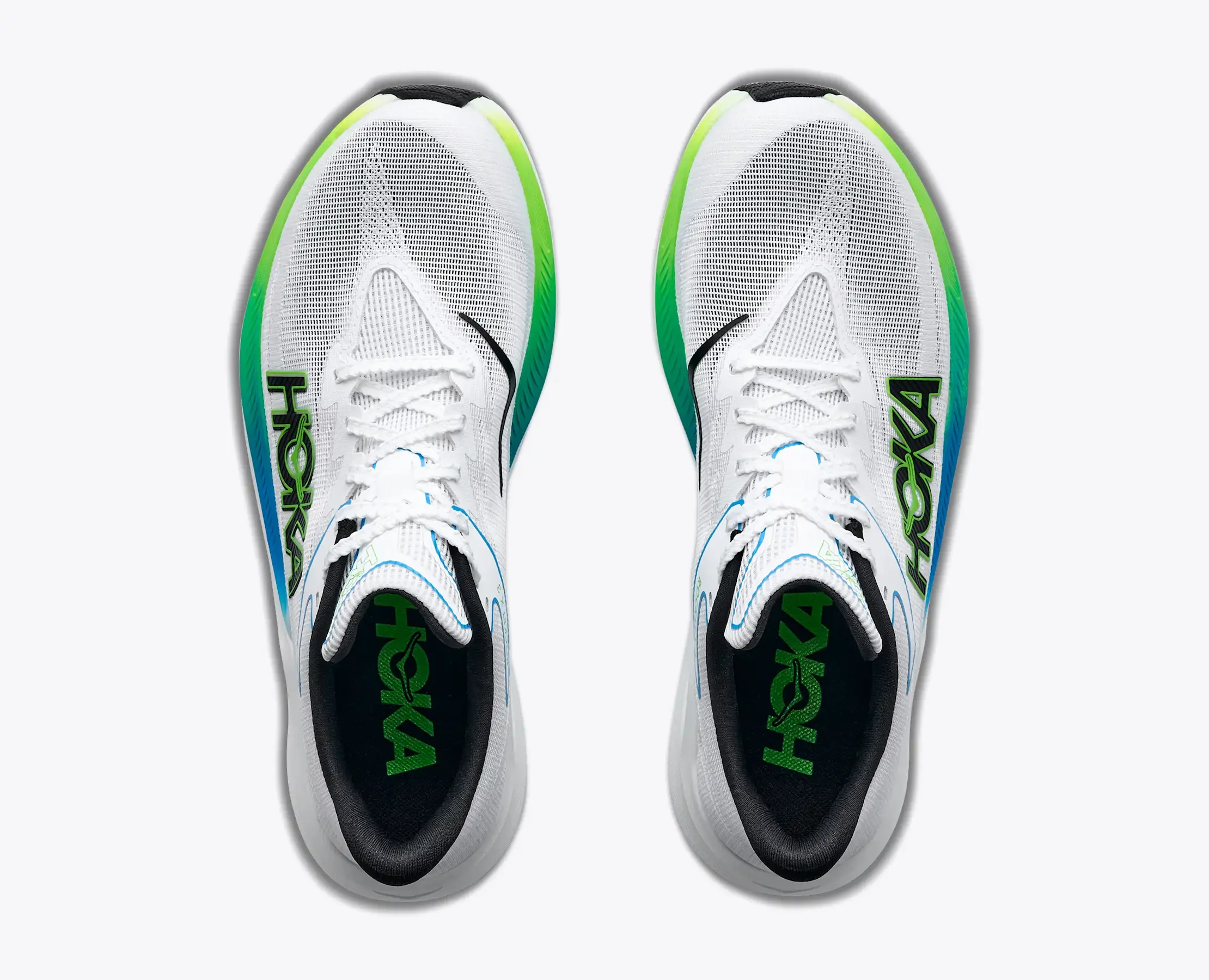 Top view of white athletic sneakers with green and blue accents, laced up with white shoelaces, on a plain white background.