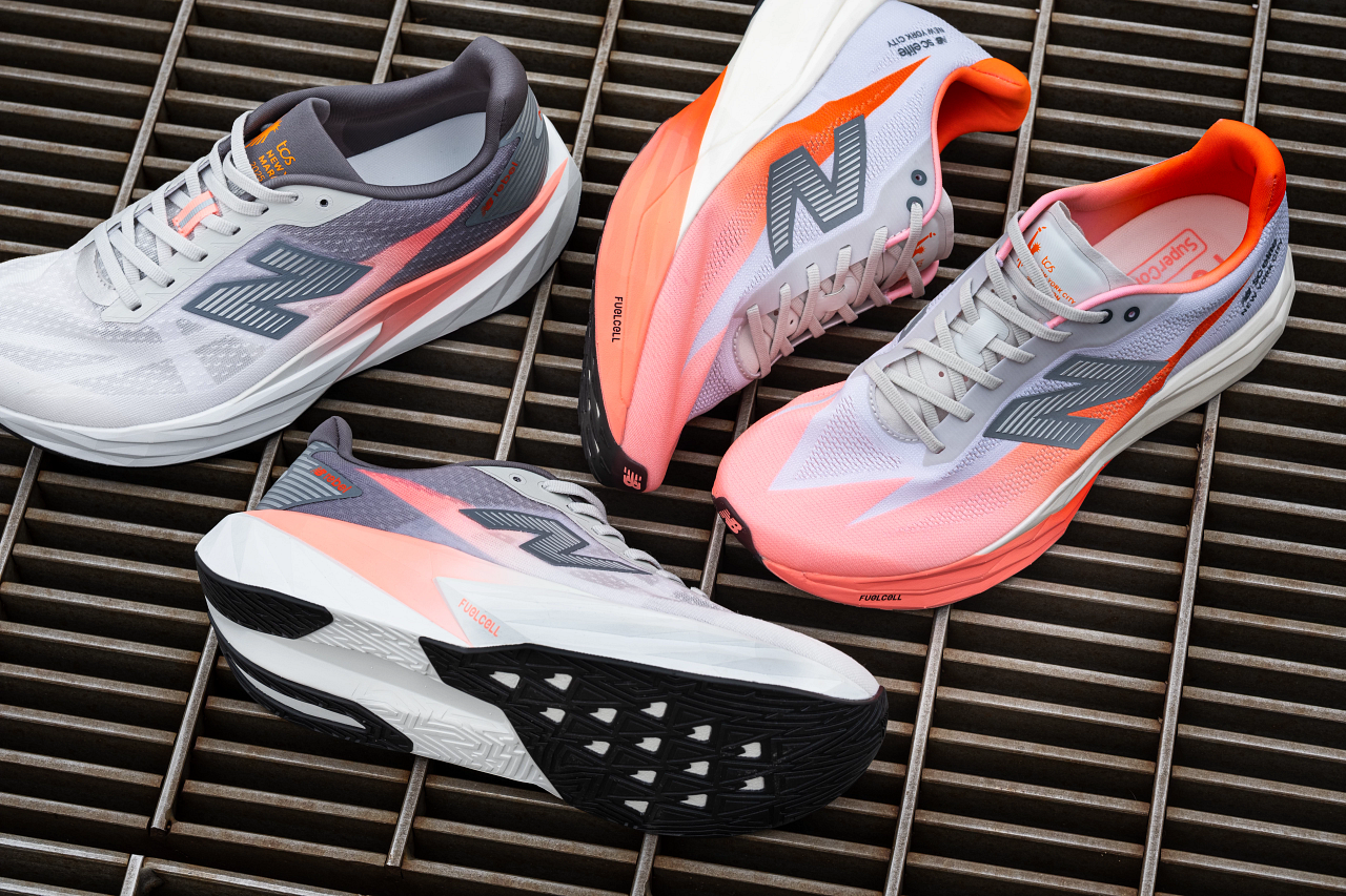Four athletic running shoes with mesh uppers in white, gray, and pink, placed on a wooden slatted surface.