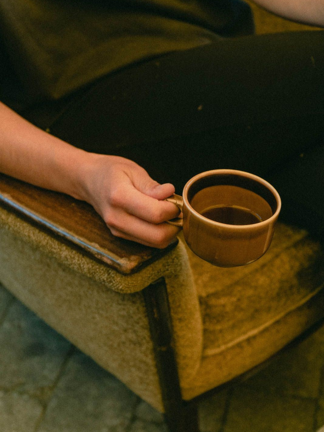 Warm interior detail at The Canopy Center ketamine therapy clinic in Rocky River Ohio — a person resting with a ceramic mug