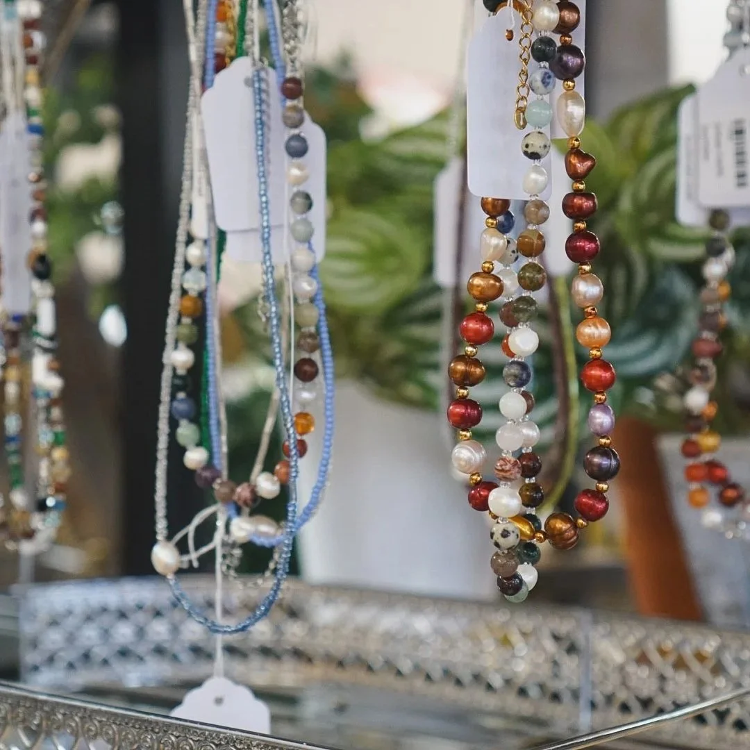 Assorted beaded necklaces hanging on display at a jewelry store.