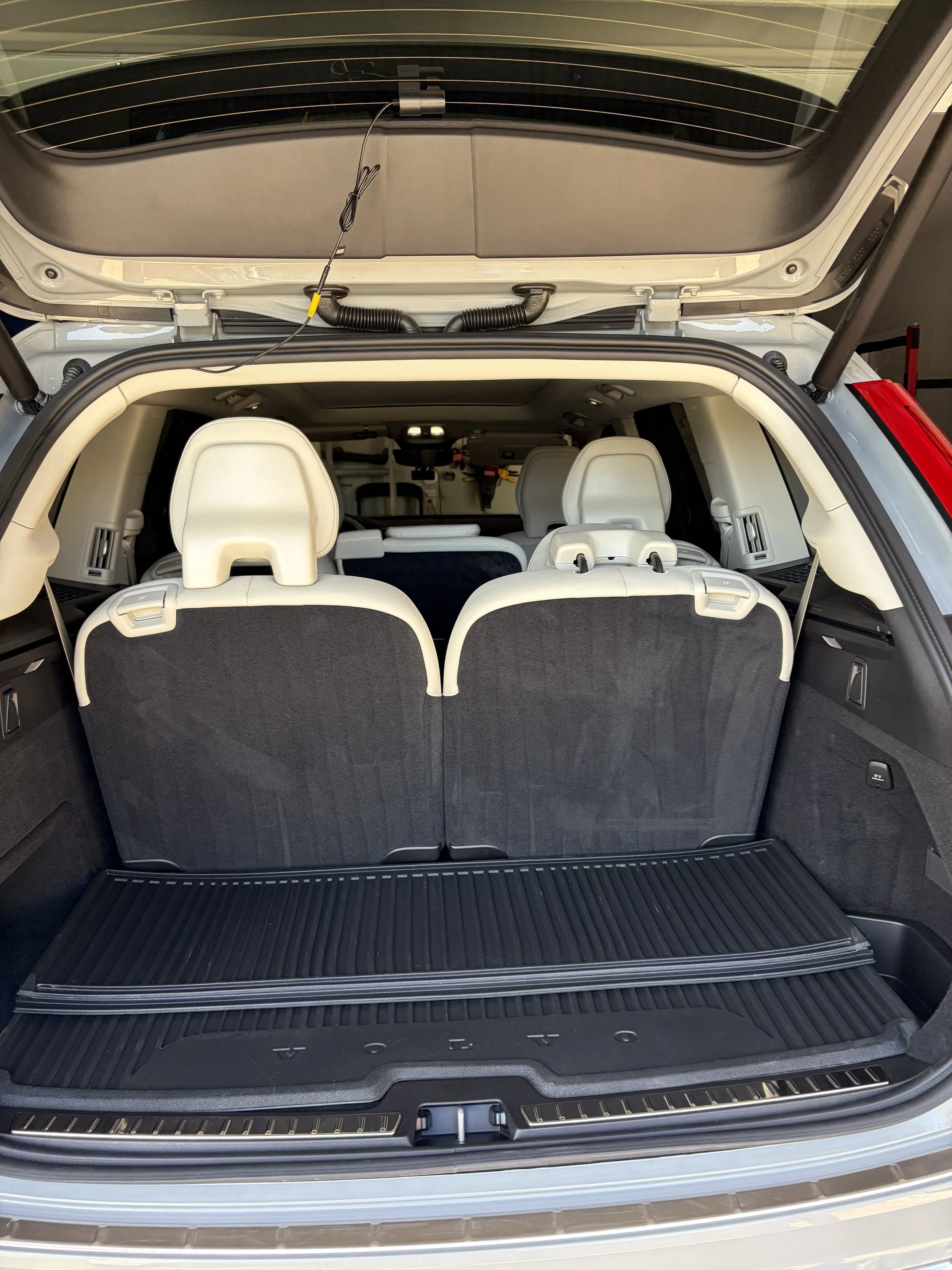 The image shows the open trunk of a vehicle with two folded down seats in the cargo area and a black rubber cargo liner on the floor.