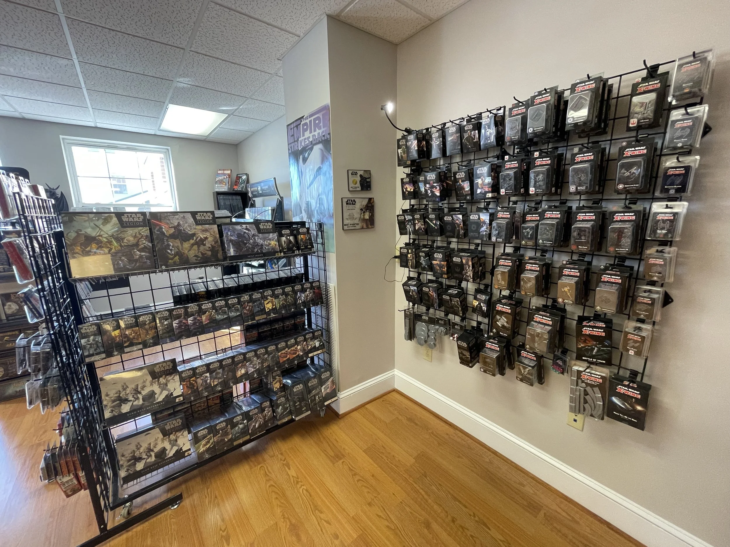 Display of Star Wars-themed collectible items, including action figures and trading cards, arranged on black metal racks in a store.