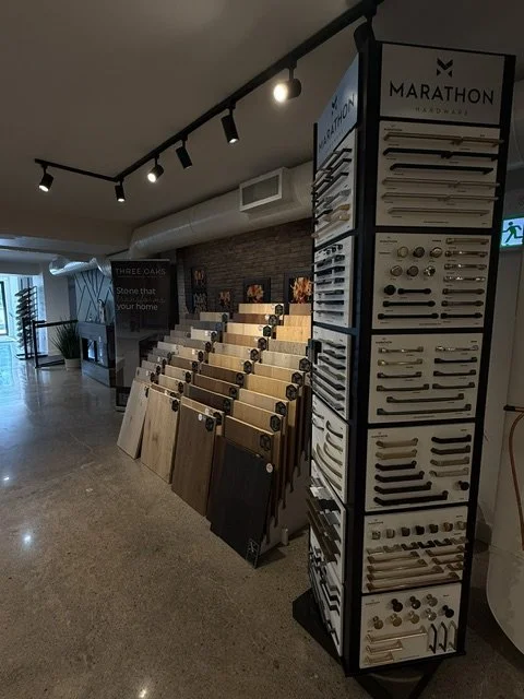 Display of hardwood flooring samples and cabinet hardware in a store.