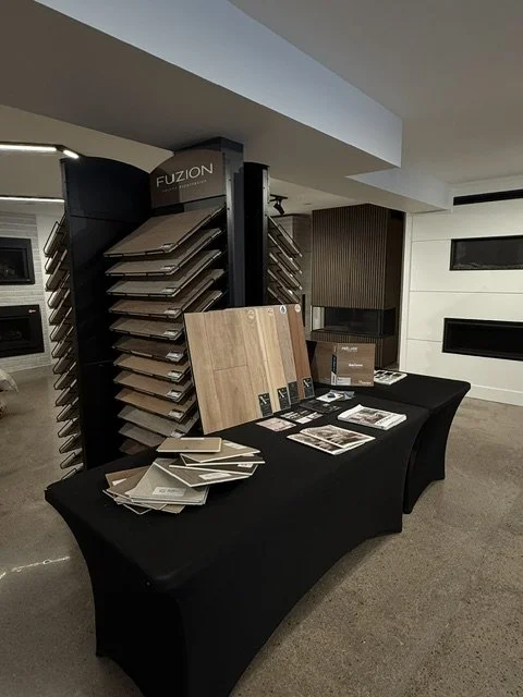 Display table with sample wood flooring options, brochures, and color samples in a flooring showroom.