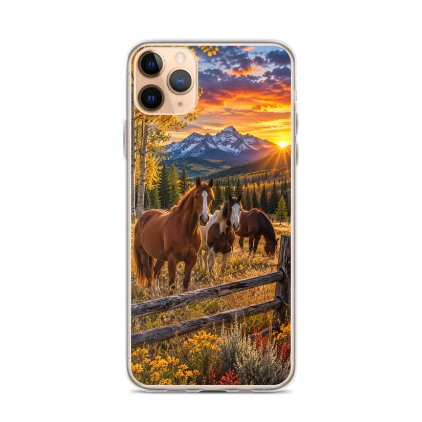 Smartphone displaying a landscape with mountains, forest, sunset, and three horses near a wooden fence.