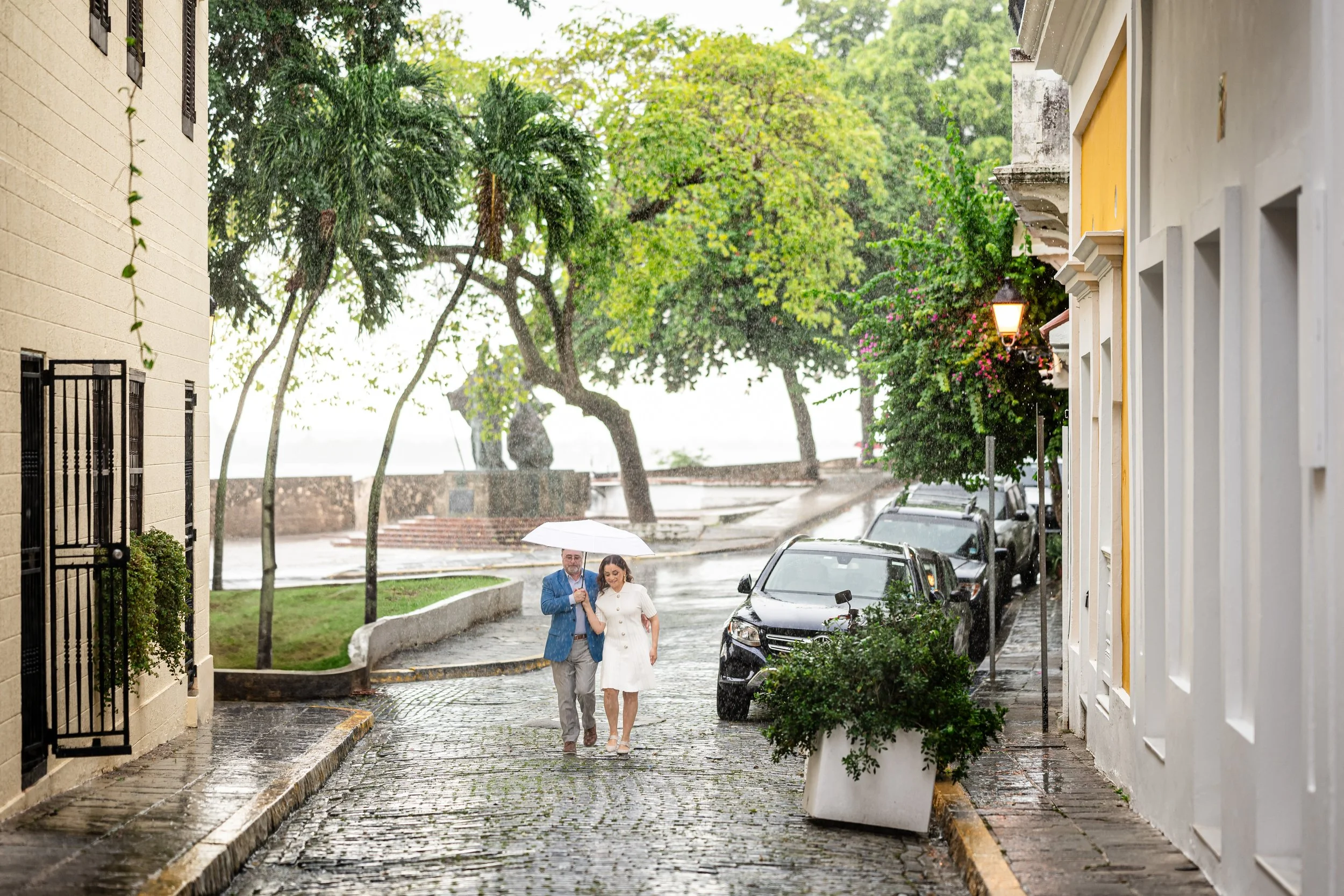Tania Lopez walking through Old San Juan under an umbrella.