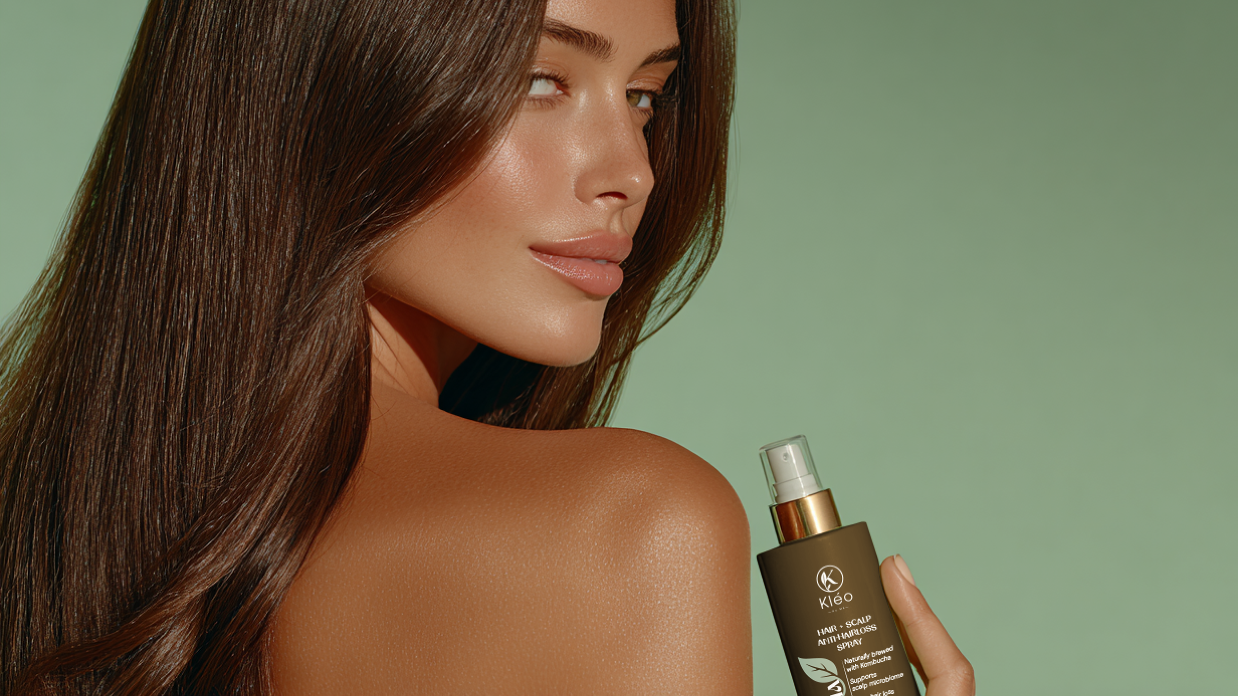 A woman with long brown hair holding a bottle of hair and scalp antioxidant spray.