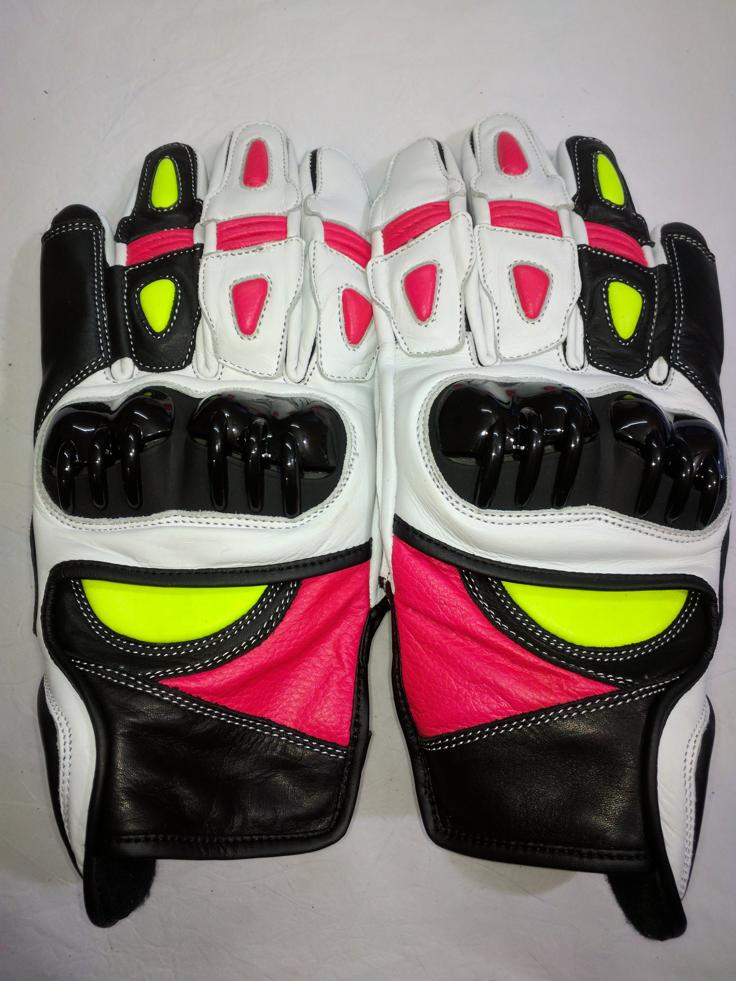 Pair of motorcycle racing gloves with a color scheme of black, white, pink, and neon yellow accents.