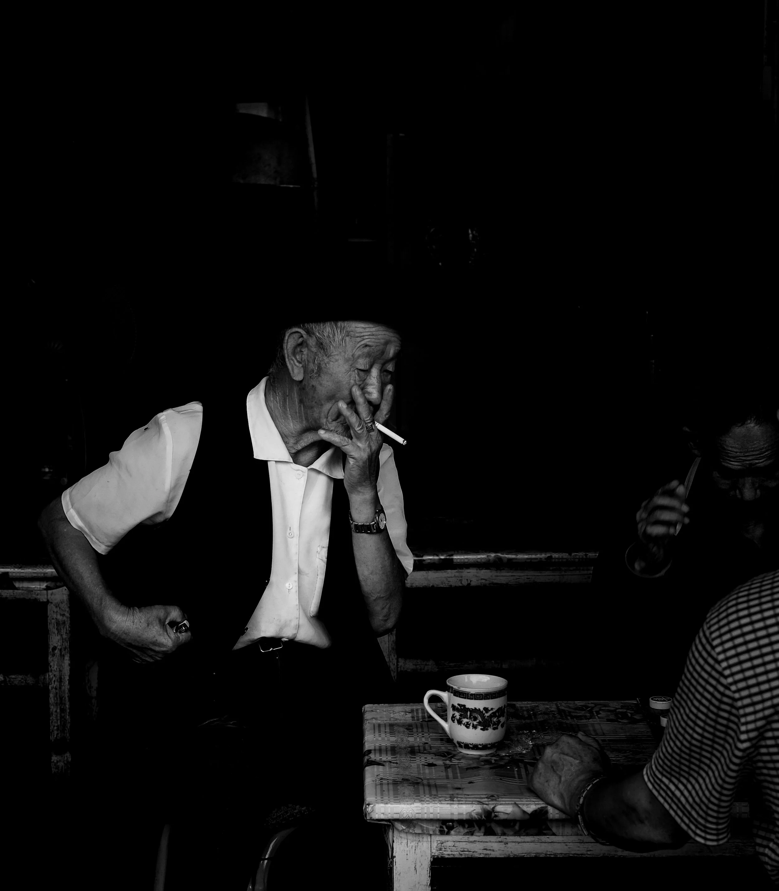 a chinese elderly man enjoying tea with friends