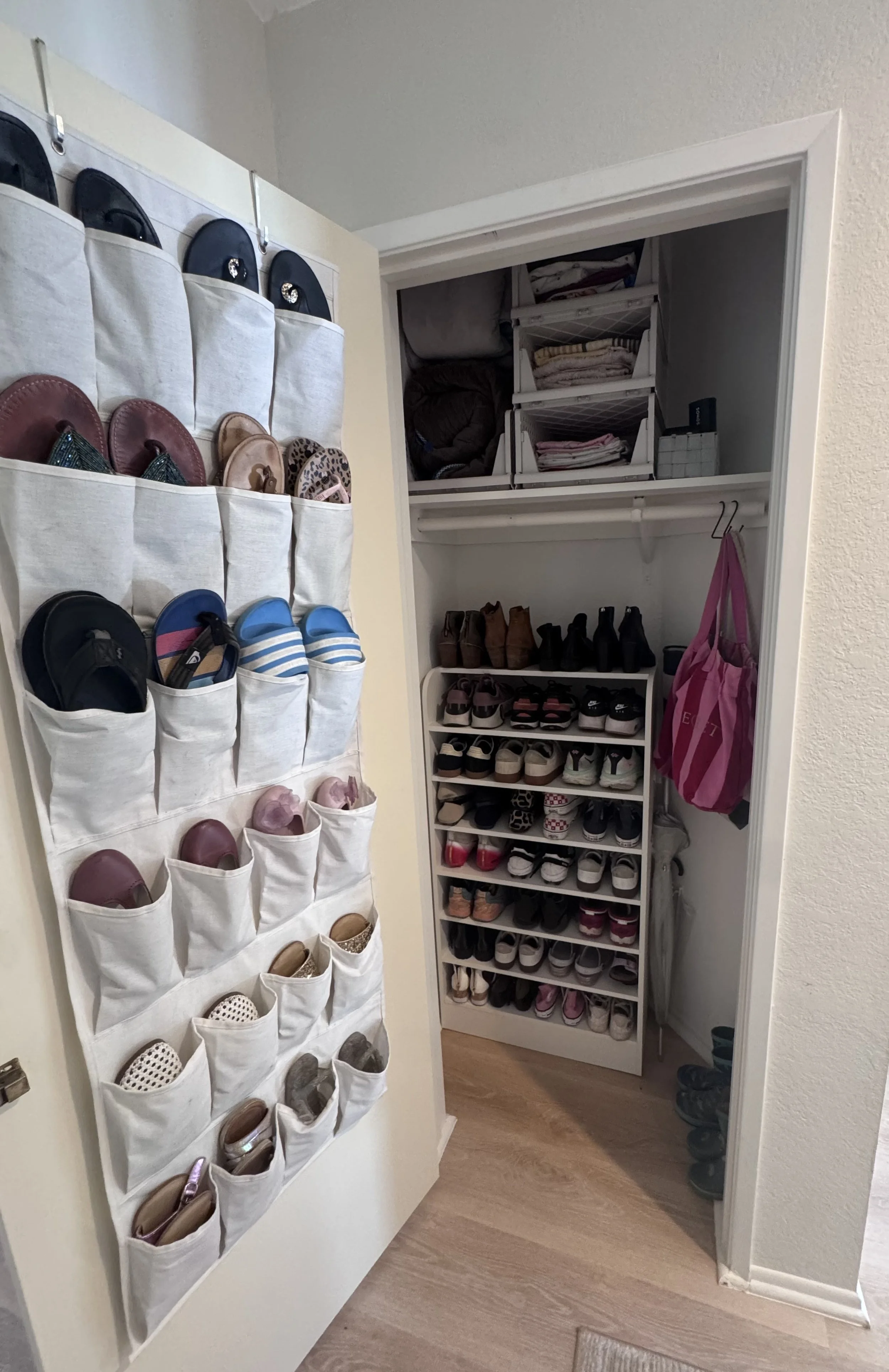 A small closet with organized shoes on shoe racks and hanging pockets for accessories, with folded clothes and storage bins inside.