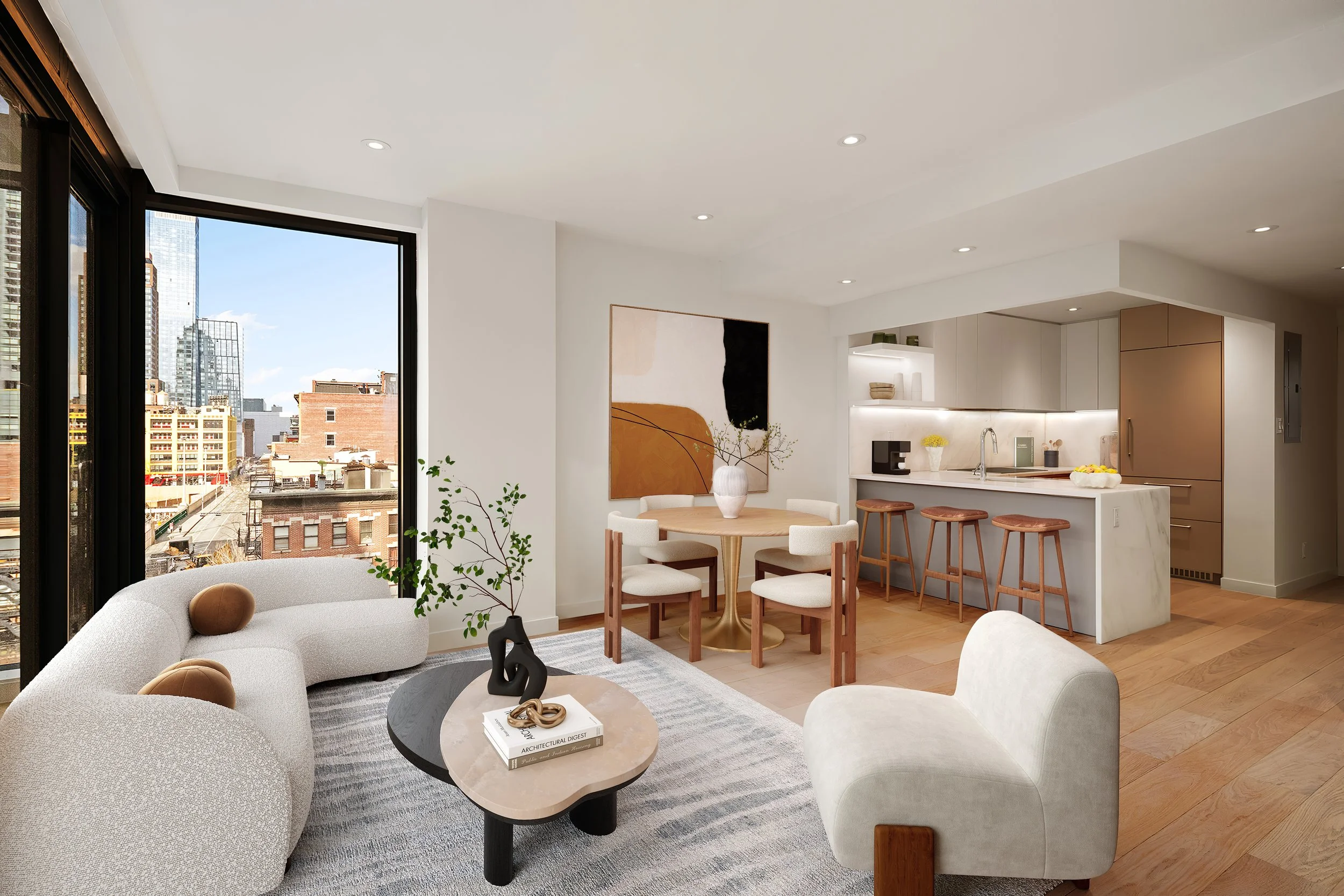 Modern and bright open-concept living and kitchen area with large windows showing city buildings, minimalist furniture, a round dining table with chairs, abstract wall art, and a kitchen with white cabinets. Developed by Ten Talents Management.
