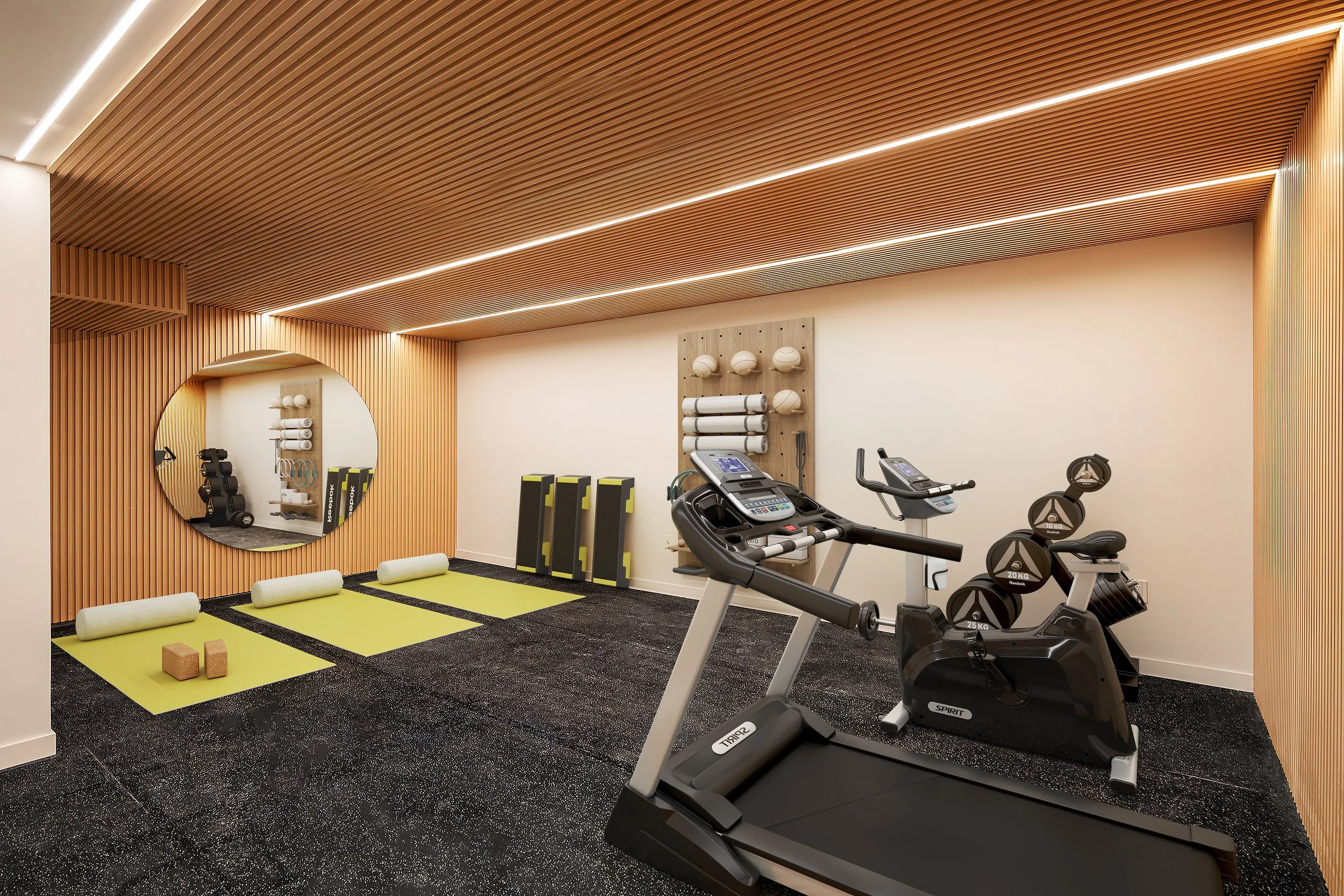 Modern gym with wooden ceiling, treadmill, stationary bike, gym equipment, yoga mats, foam rollers, and weights. Developed by Ten Talents Management.