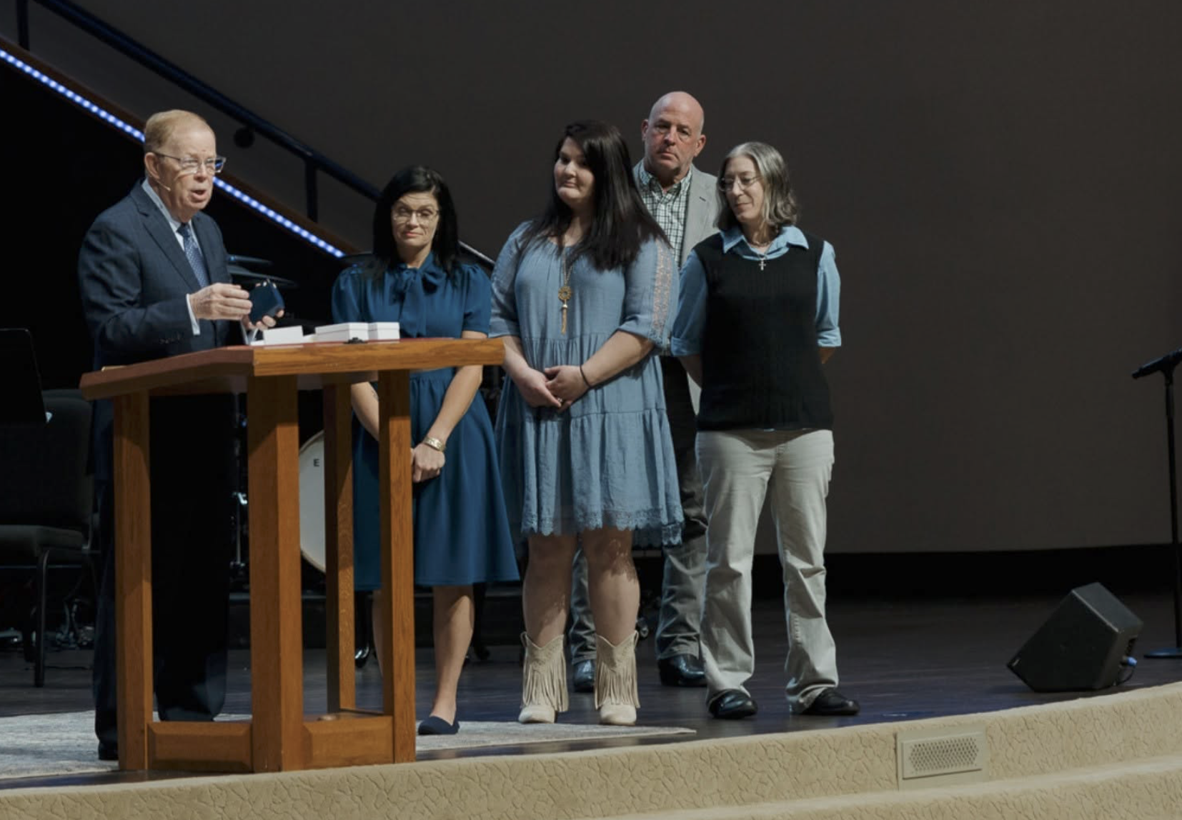Charis House woman standing with church leaders and supporters during a recognition moment at Olive Baptist Church in Pensacola