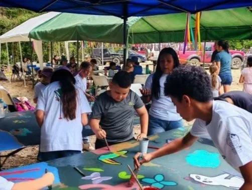 Children and adults enjoying arts and crafts activities under colorful tents at an outdoor event.