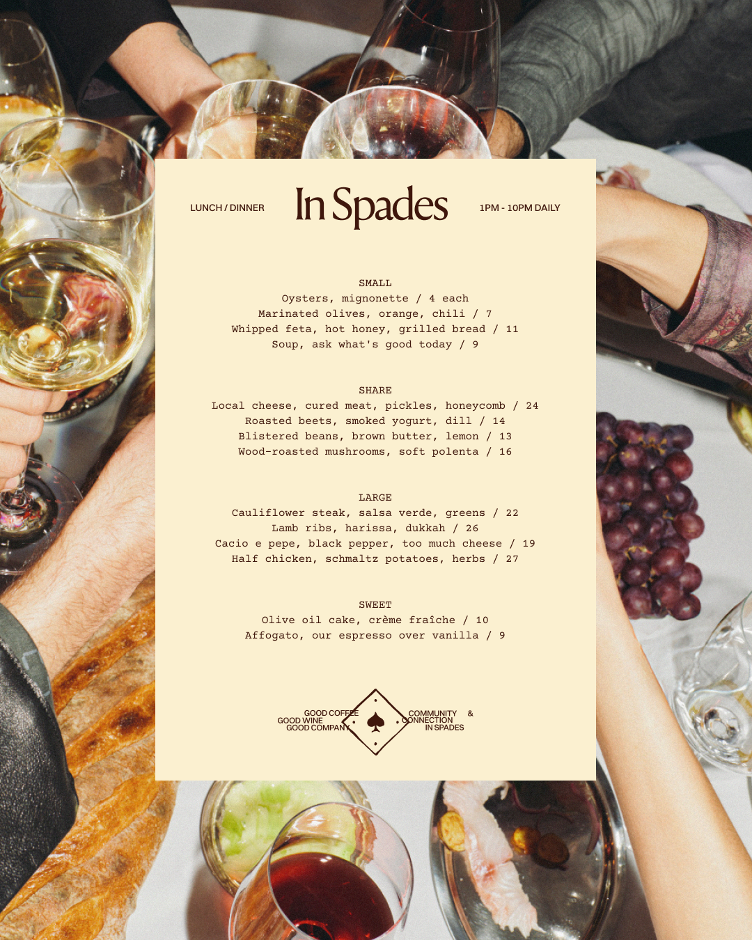 A menu for a restaurant called In Spades, featuring lunch and dinner options from 1 PM to 10 PM daily. The menu includes small, share, large, and sweet dishes such as oysters, marinated olives, whipped feta, soups, cured meats, cheeses, lamb ribs, chicken, desserts, and wines. The background shows a table with glasses of wine, grapes, bread, and various dishes, with some people reaching across.