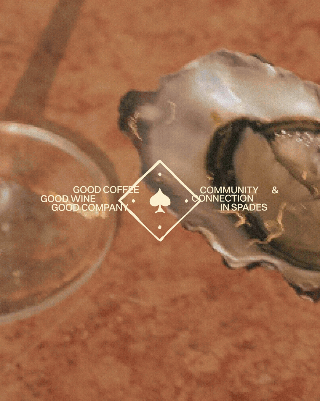 Close-up of a croissant, chess pieces, olives, and oysters with a graphic overlay that reads, 'Good coffee, good wine, good company, community & connection in spades'.
