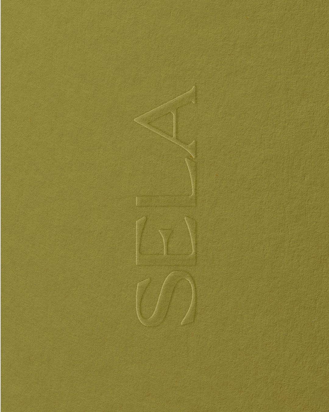 Close-up of embossed SELA logo on a yellowish-green textured surface.