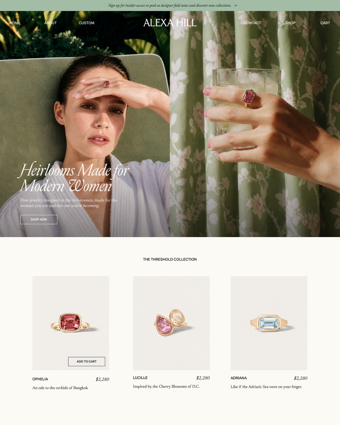 Website homepage design for Alexa Hill jewelry featuring a woman wearing a pink gemstone ring, with a close-up of the ring on a hand holding a glass in front of a floral curtain, and a collection of three rings with descriptions and prices.