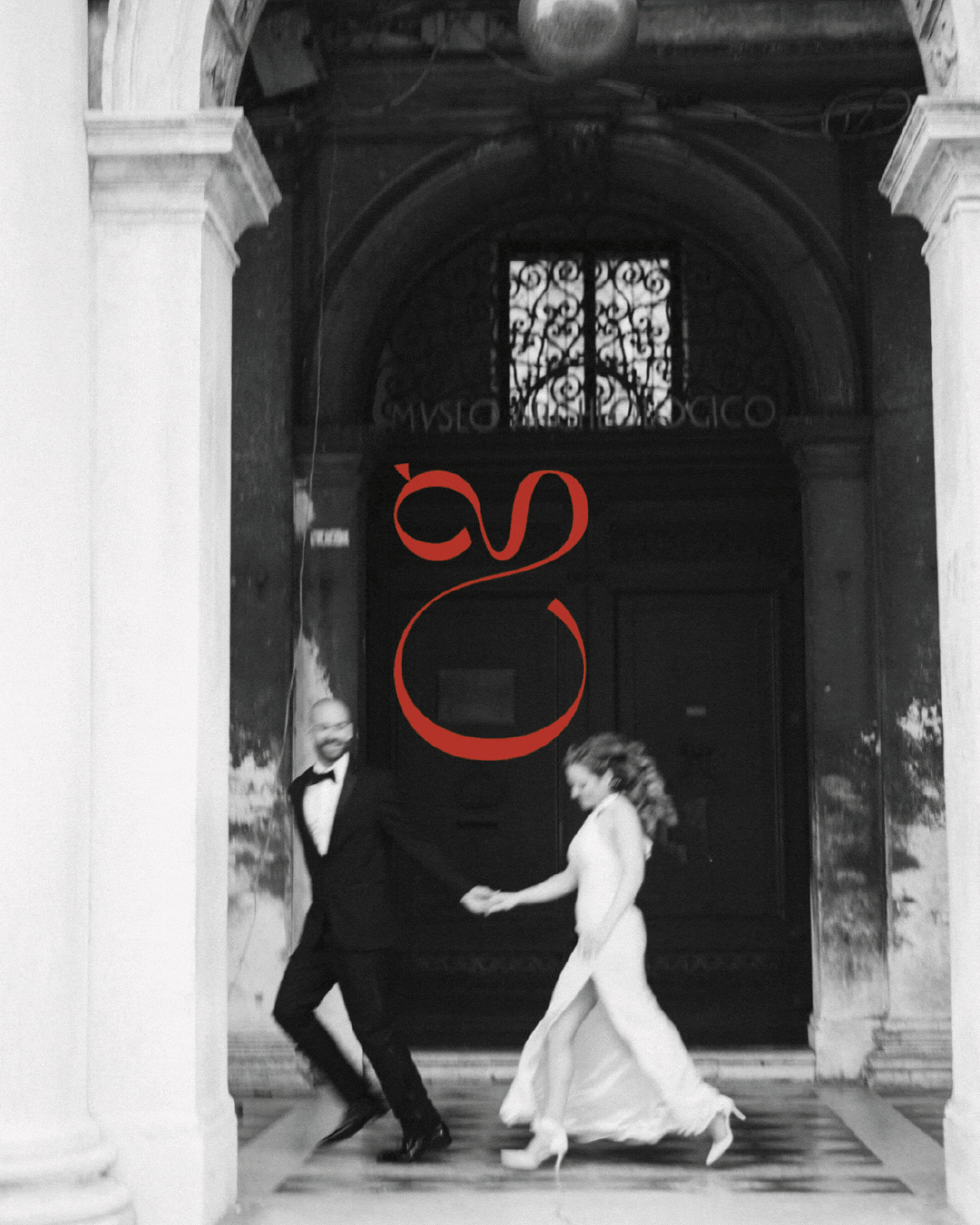 A black and white photo of a man and woman in wedding attire holding hands. There is red logo overlay on the image.