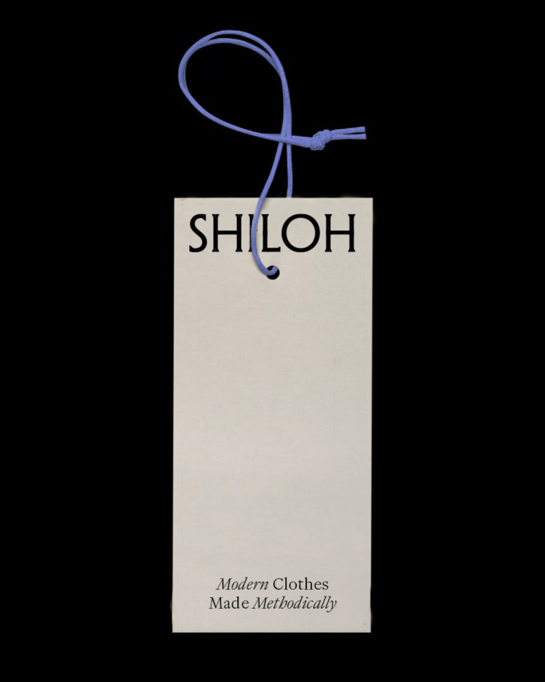 Clothing tag with black Shiloh logo and smaller text below that says "Modern Clothes Made Methodically," attached to a blue string tied in a knot.