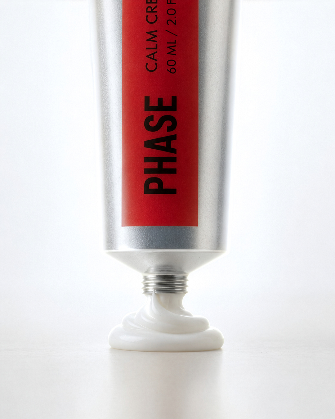 A silver tube of white cream with a red label with the Phase skincare logo with text indicating it is skincare cream.