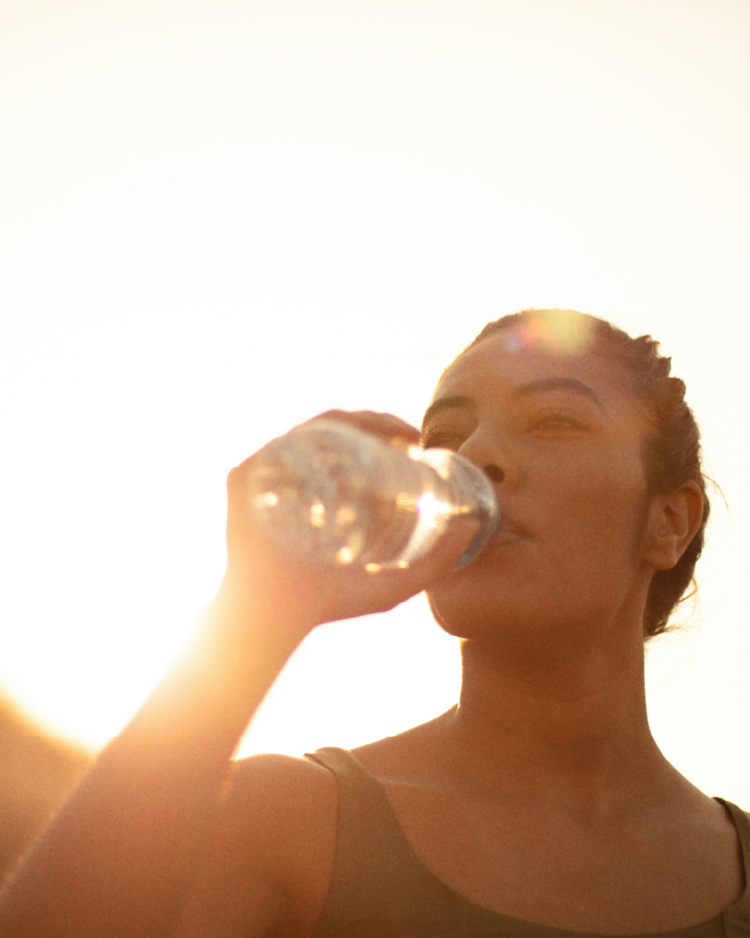 Woman drinking water during sunset