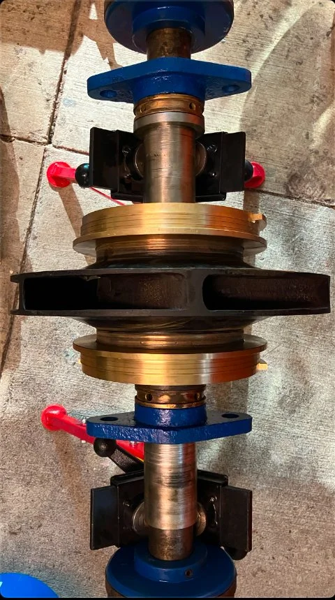 A large industrial valve assembly with metal and plastic components, mounted on a concrete floor.