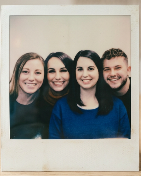 Four young people smiling for a photo with obvious closeness, belonging, and a trusting friendship with one another.