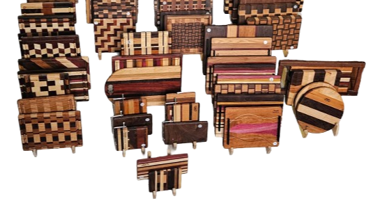Collection of various wooden cutting boards with different geometric and striped patterns.