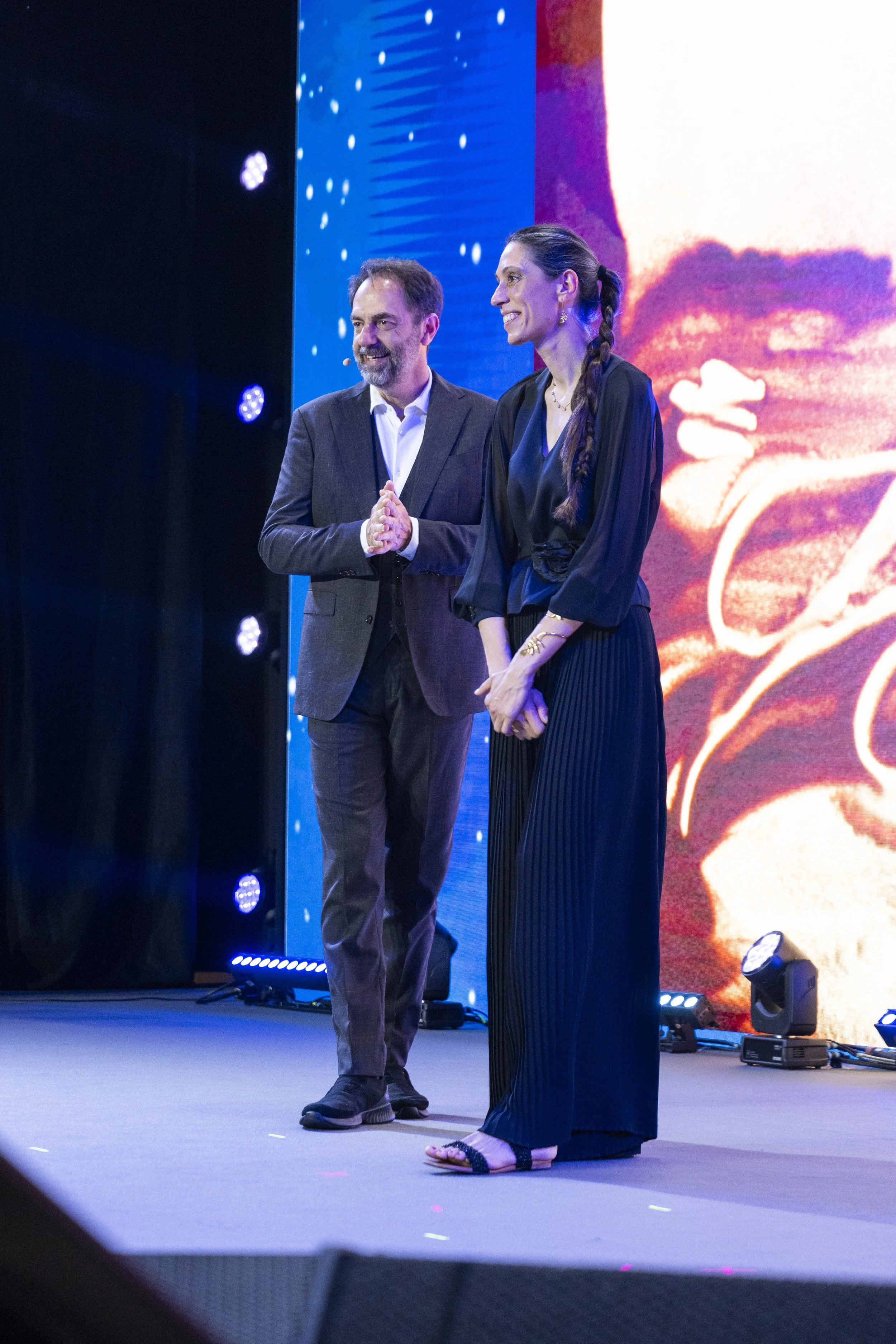 artista-nadia-pretto-con-neri-marcore-palco-tanka-village-sardegna-convention-credem-euromobiliare-legami-sand-art-spettacolo-sabbia.jpg