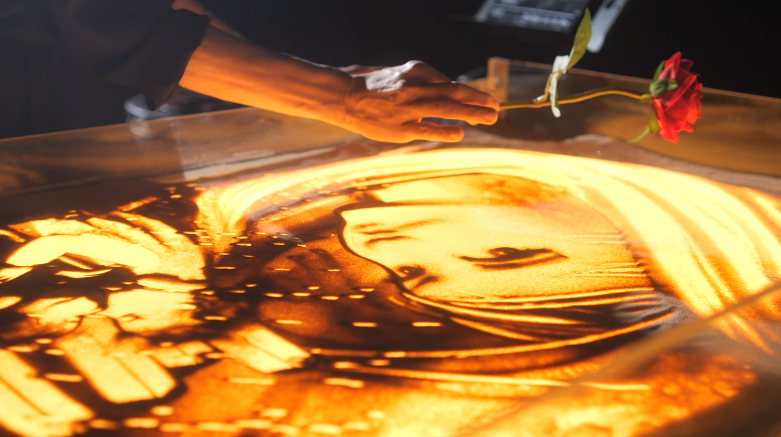 Frame dello spettacolo Sand Frames di Nadia Pretto, disegno di sabbia dedicato al cinema e a Colazione da Tiffany
