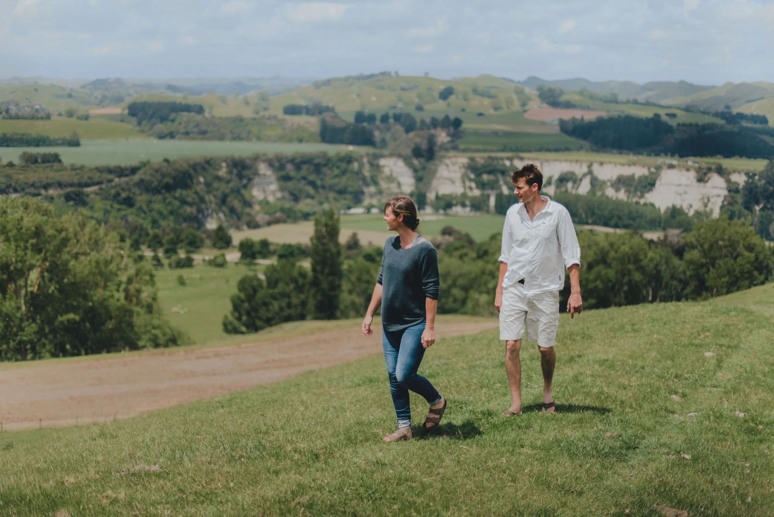 Couple enjoying a Farm Walk overlooking the rolling fields, Rangitikei River and White Papa Cliffs.