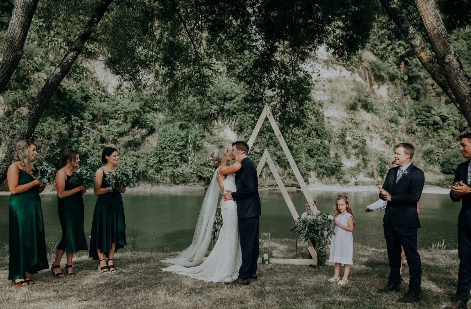 Couple kissing at outdoor wedding by the Rangitikei River at Rathmoy Estate near Manawatu.