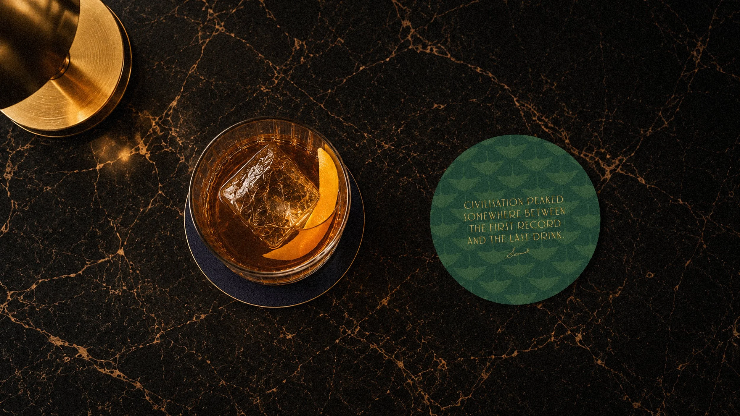 A drink and Ciddor's coaster on a dark marble bar