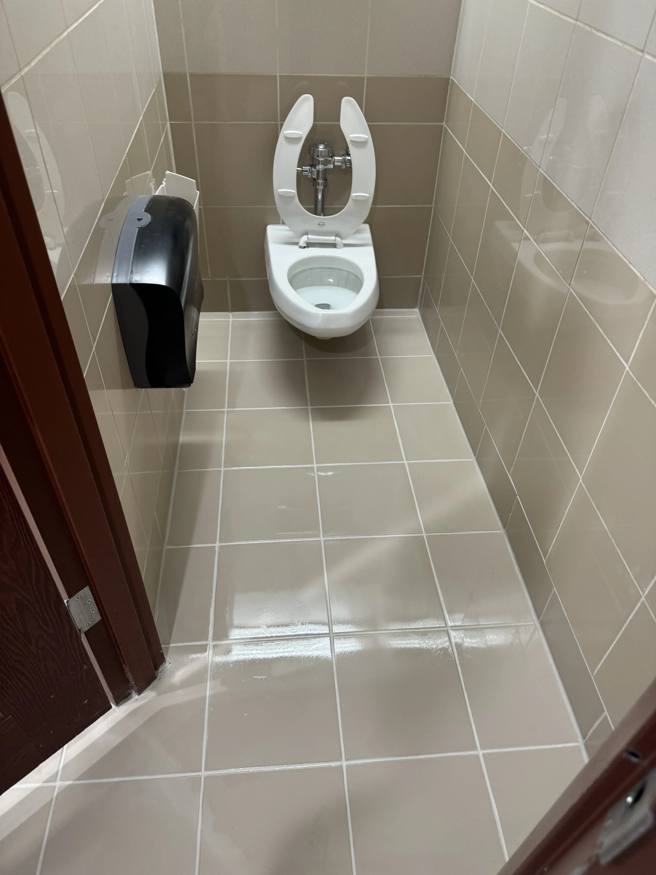 Commercial restroom tile and grout sanitized with HEPA extraction, and coated with Siltanium Non slip floor sealing and epoxy color sealed grout lines in Boca Raton.