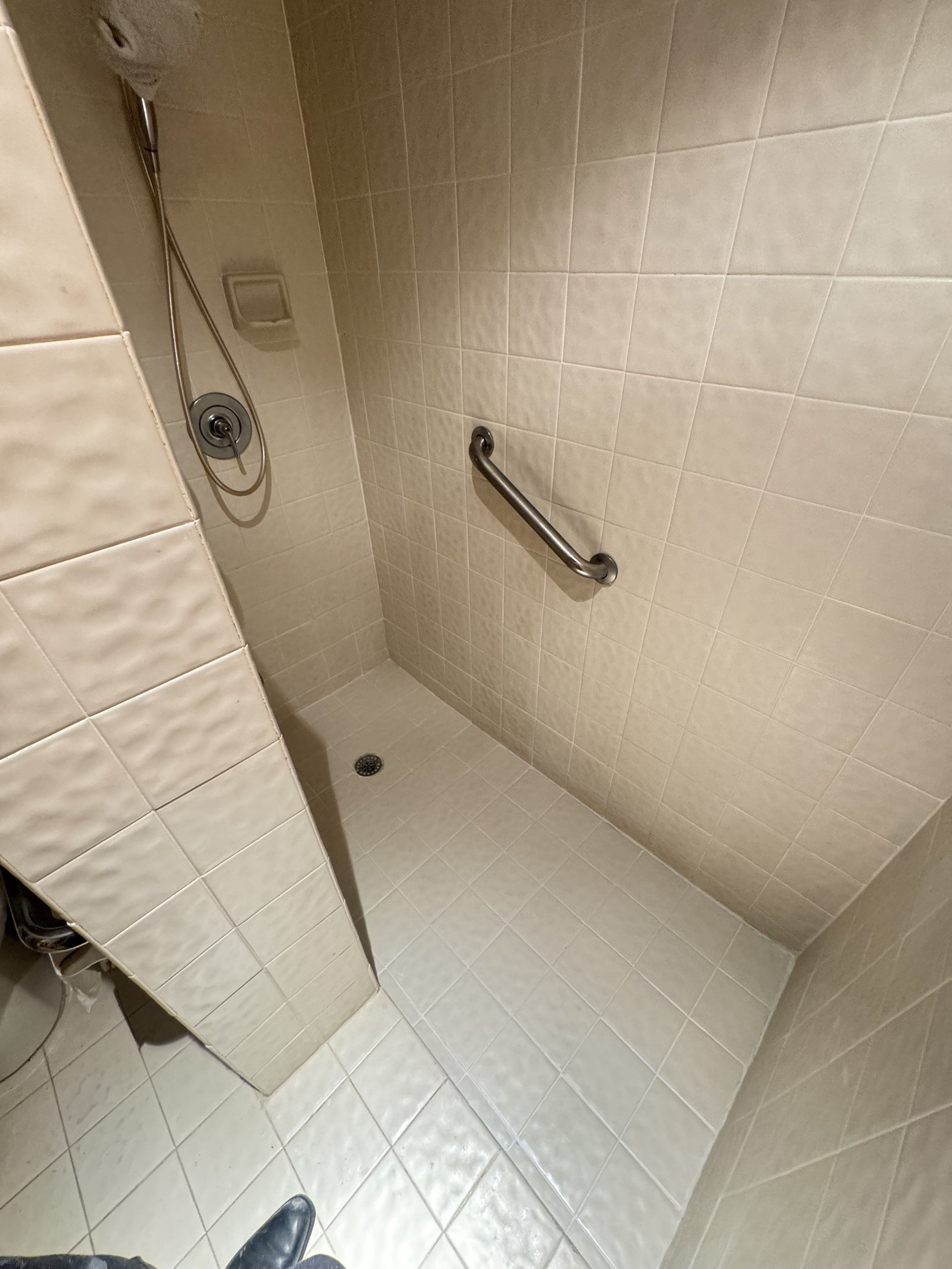 Walk-in shower with pristine beige tile and waterproof Caponi grout in Fort Lauderdale.