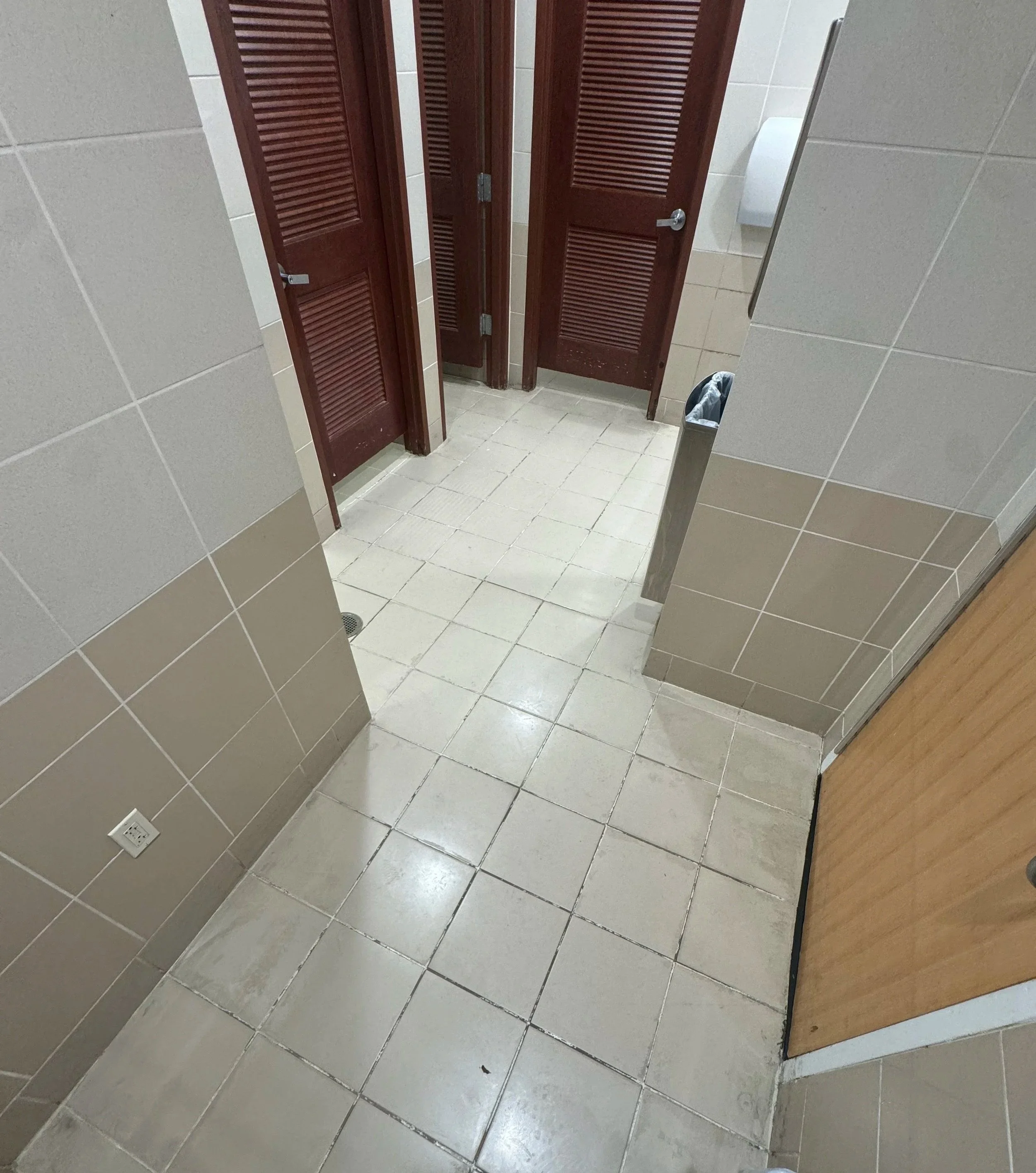 Men's commercial restroom beige tile walls and floor after grout sealing in Boca Raton.