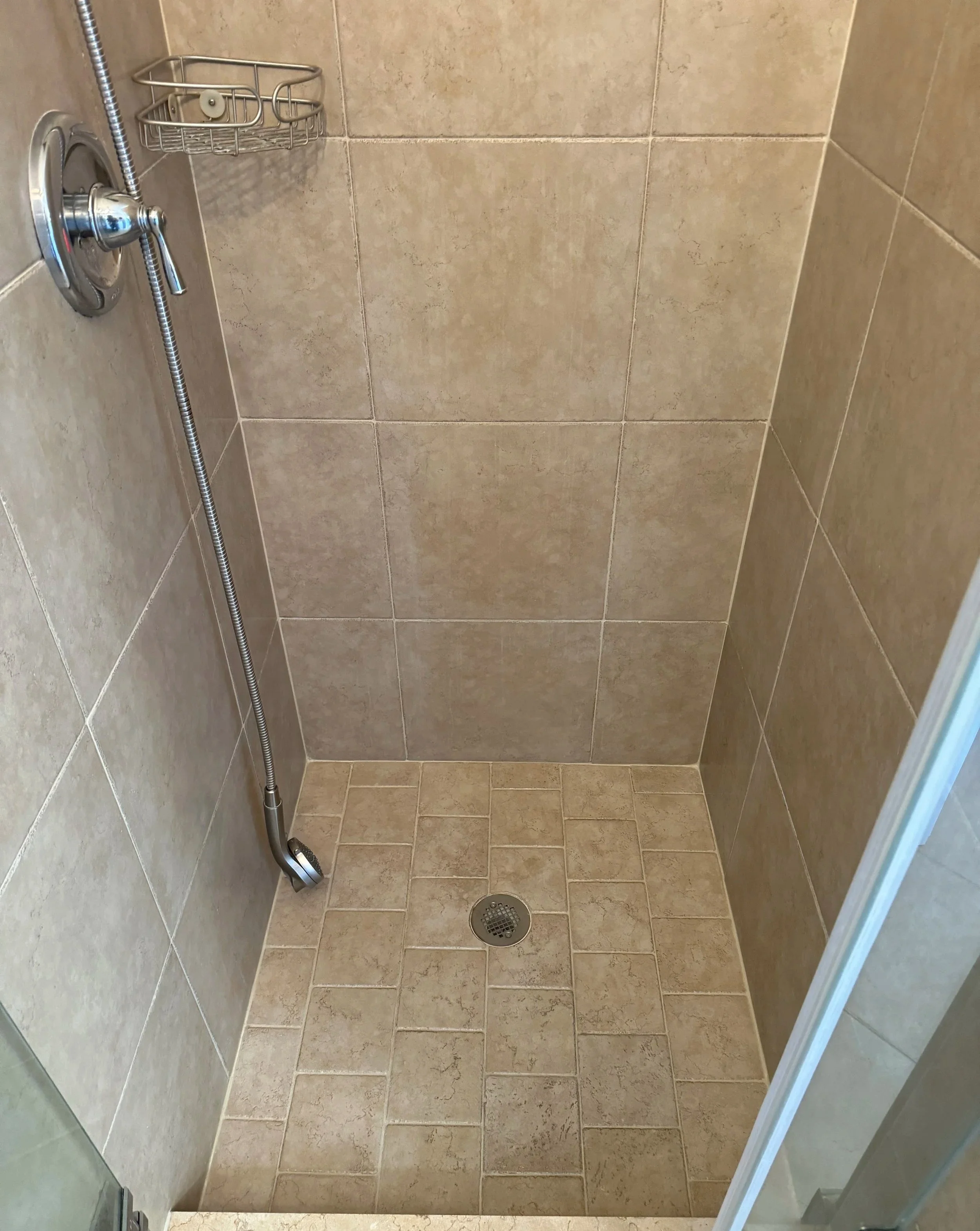 Fully restored beige tile shower with Litokol epoxy caulking in Boca Raton.