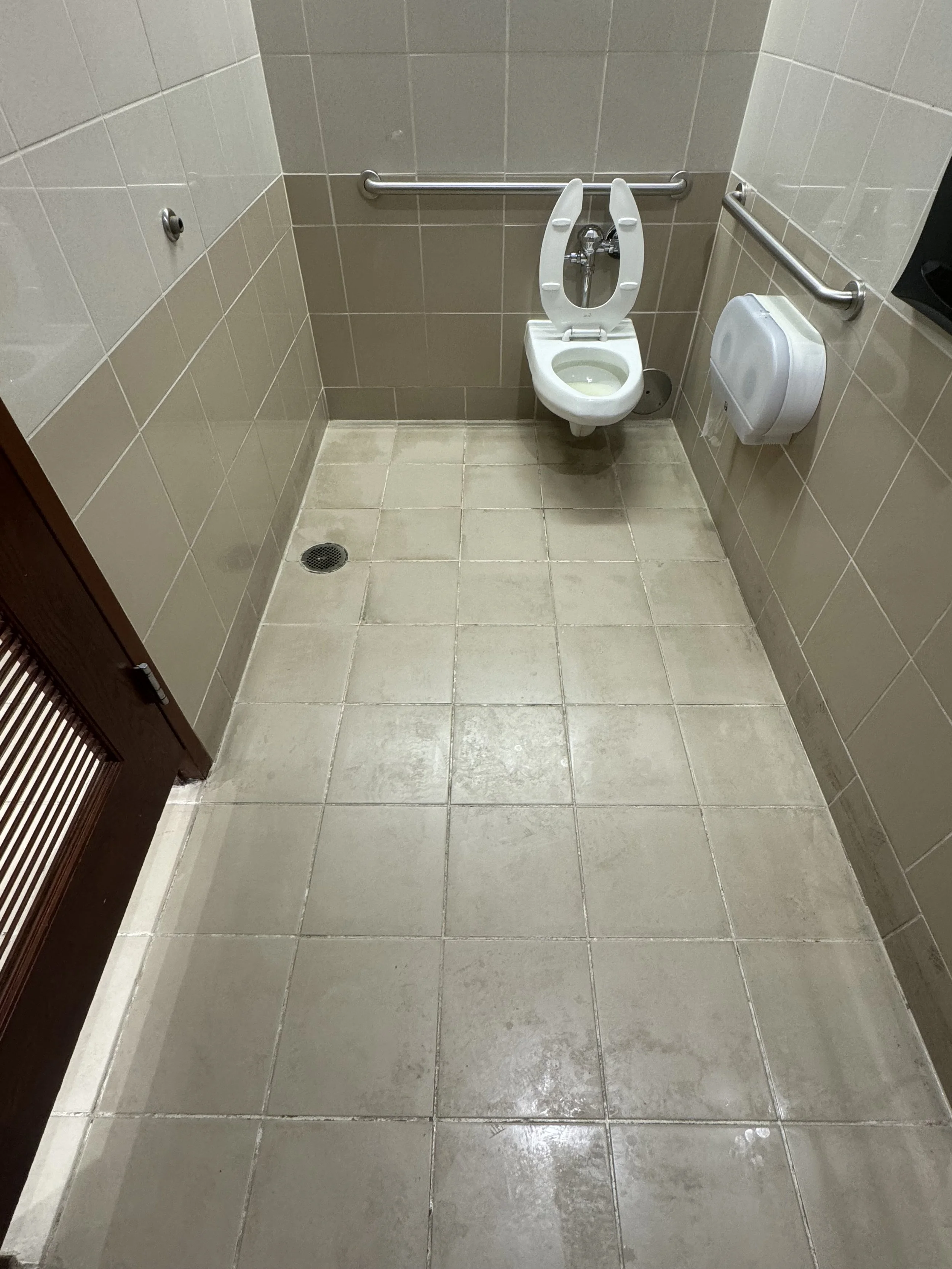 Beige and tan tiled public restroom restored with premium epoxy sealing in Fort Lauderdale.