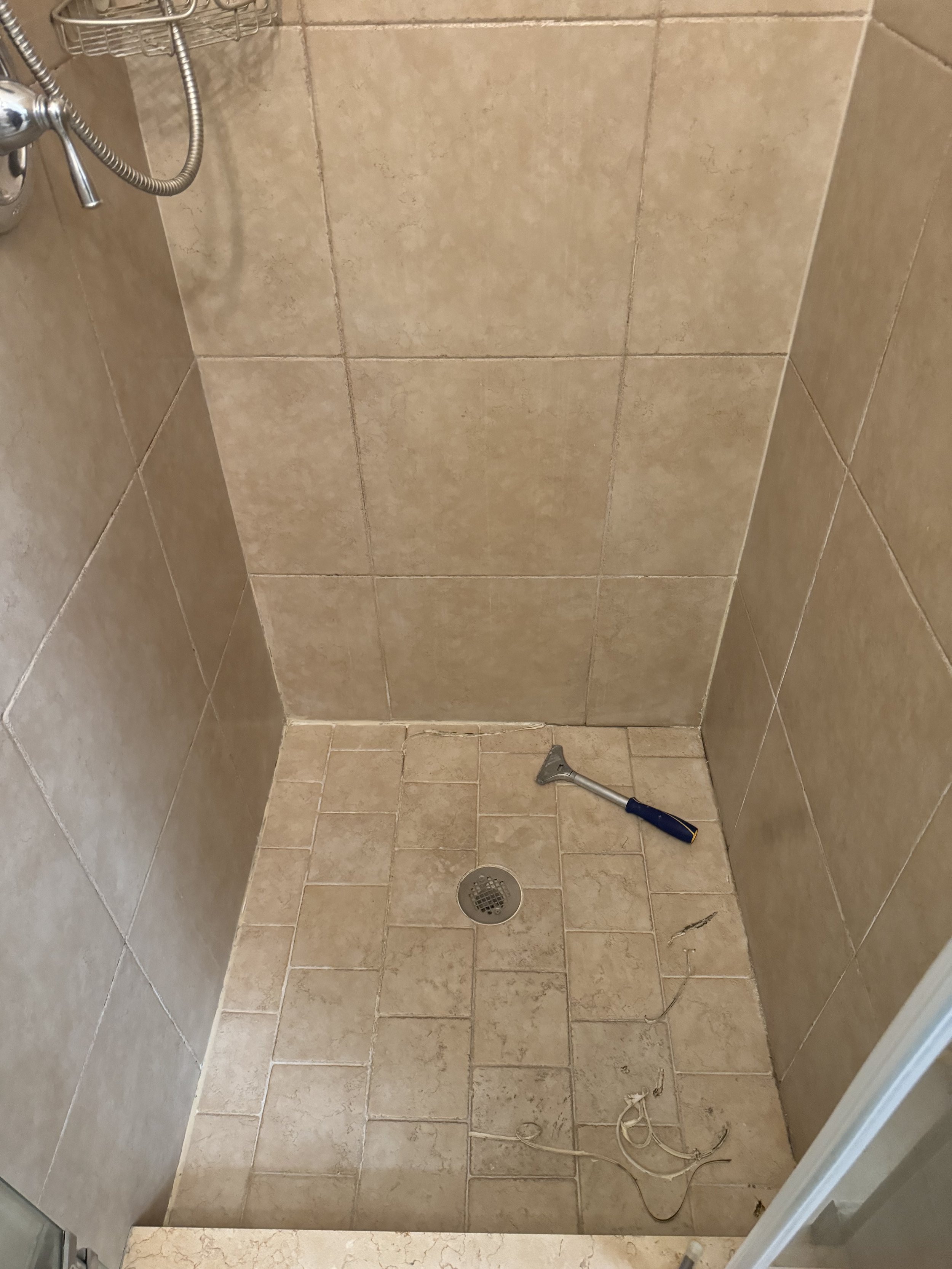 Shower stall undergoing tile and grout restoration prep work in Coral Springs.