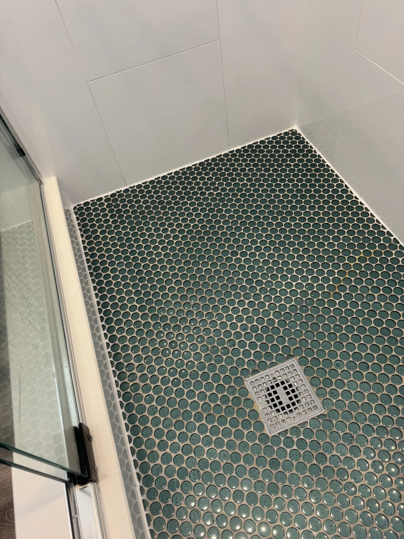 Dark green circular tile bathroom floor with sealed grout in Boca Raton.