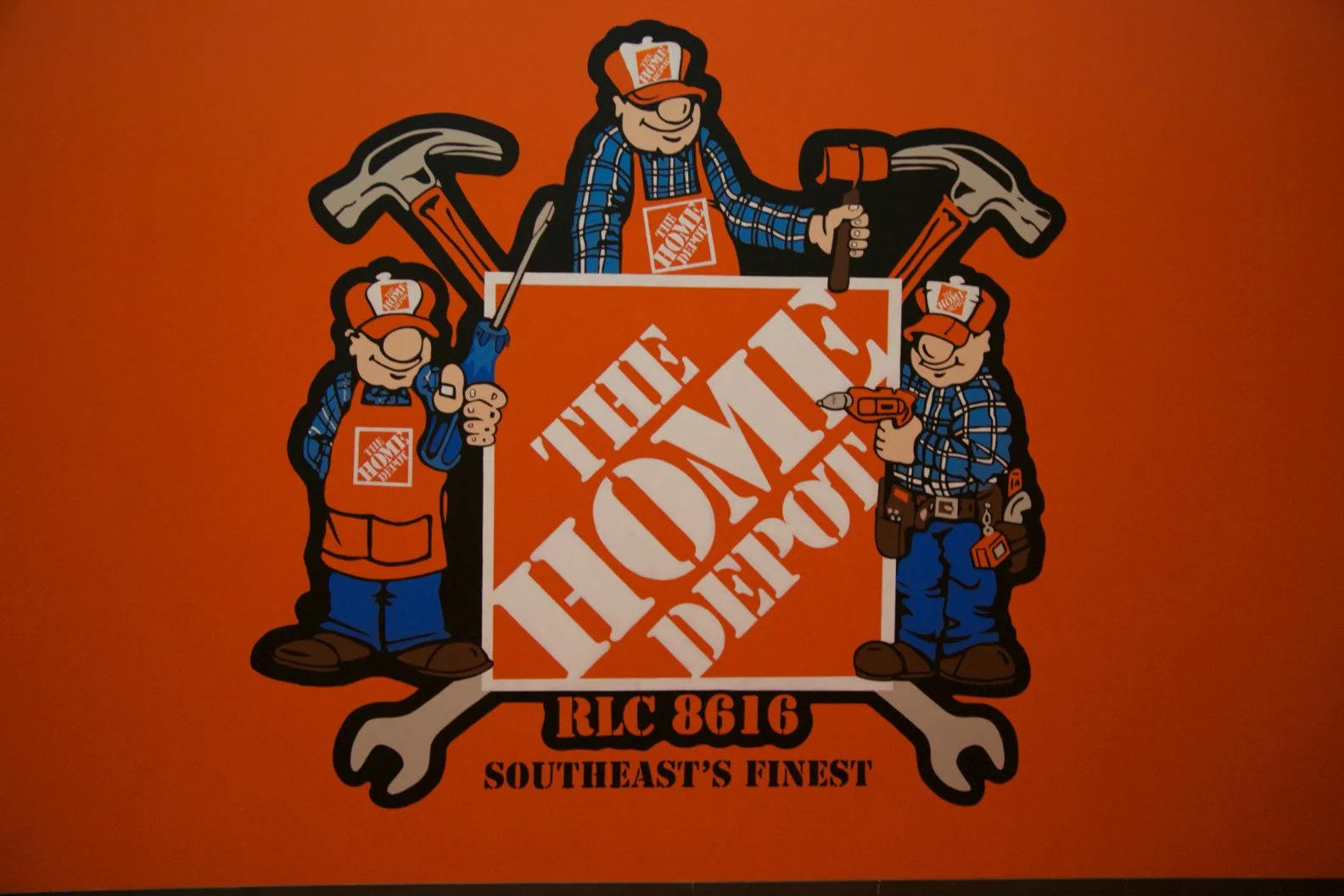 Illustration of three cartoon workers with tools, on an orange background, surrounding the logo of The Home Depot with the text 'RLC 861G Southeast's Finest'.