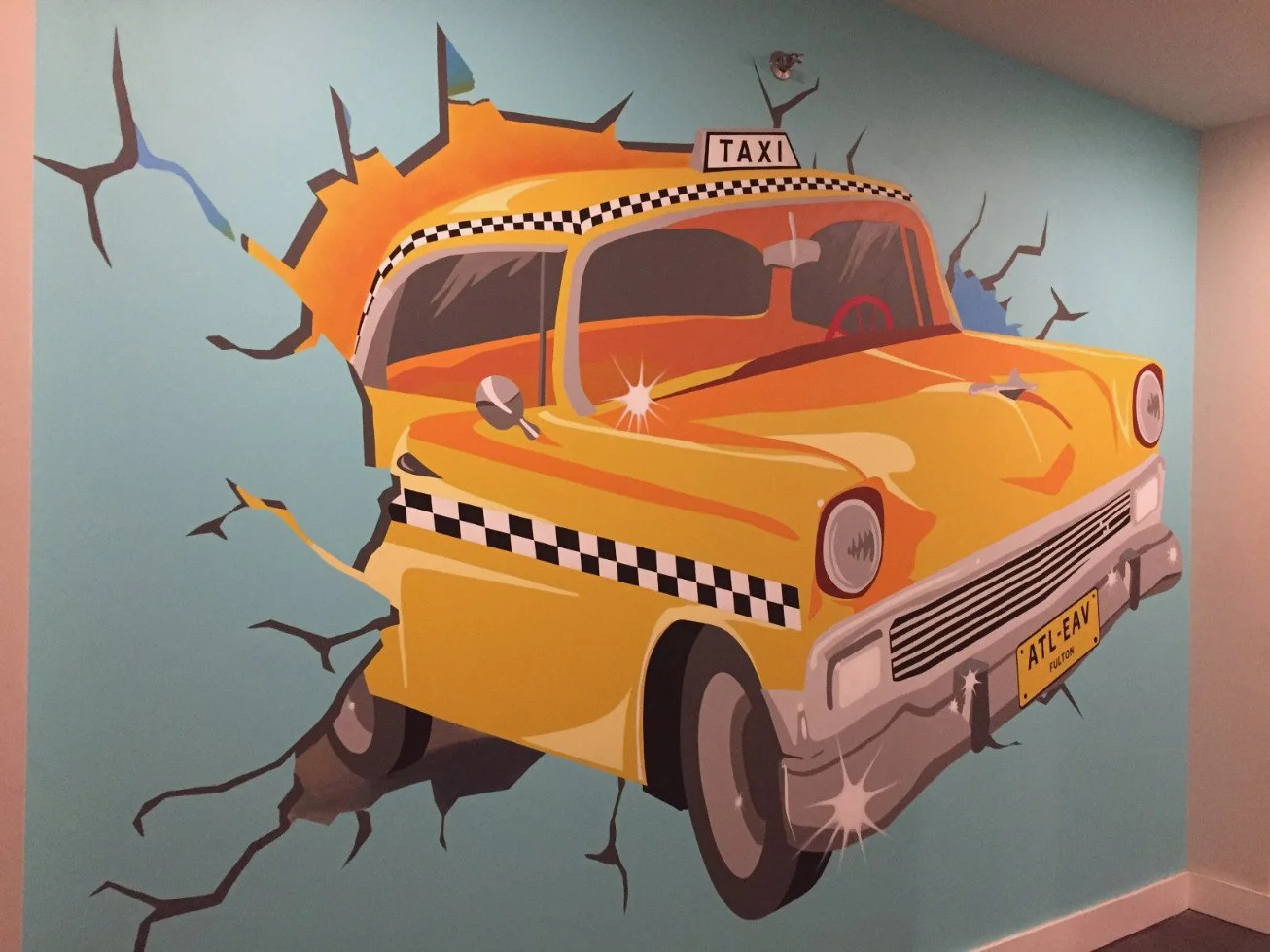 Colorful mural of a yellow taxi cab crashing through a wall with cracks and holes, featuring a checkered stripe and a license plate reading 'ATL-EAV'.