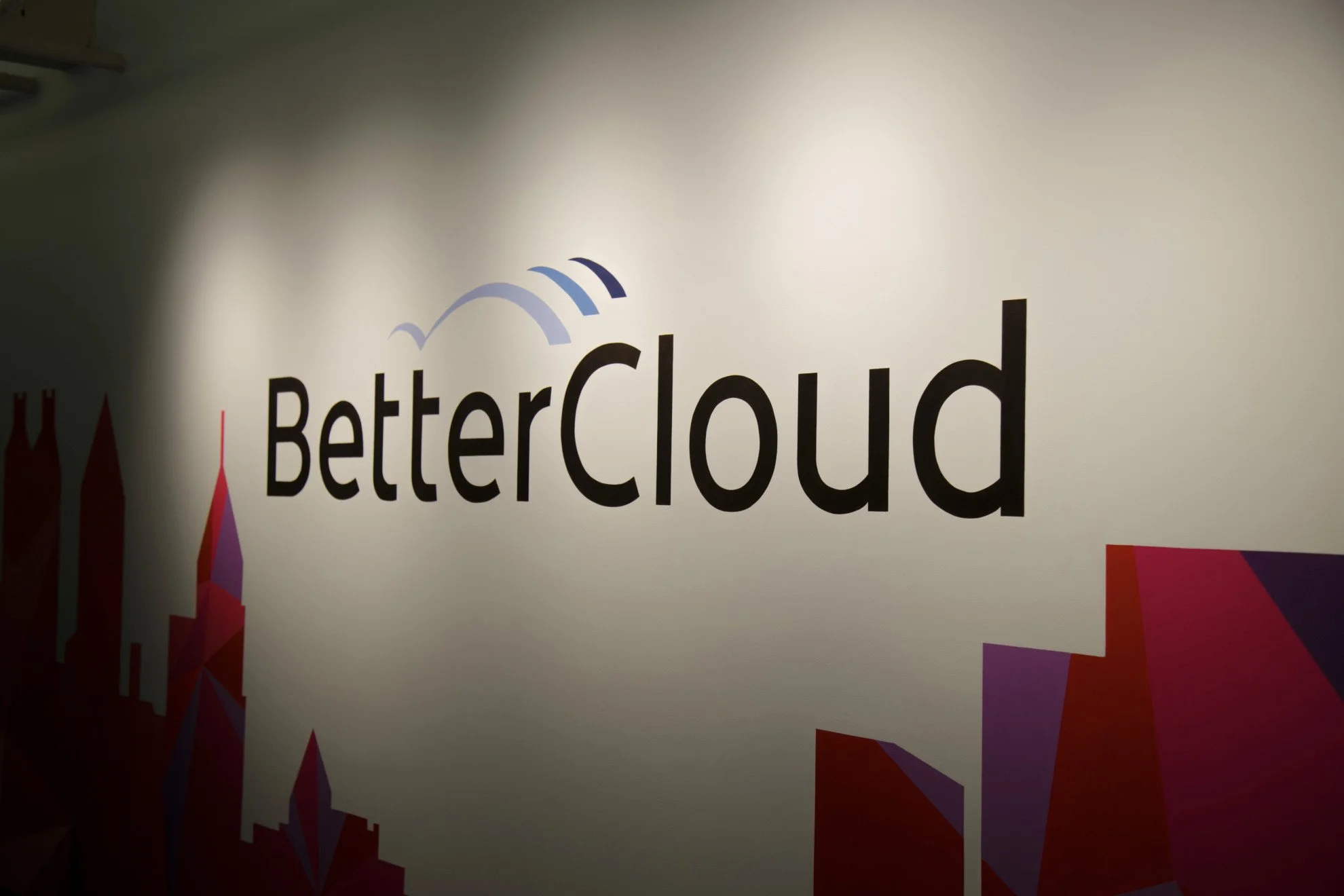 Sign with the words "Better Cloud" and a cloud icon above the text, part of a colorful graphic design on a wall.