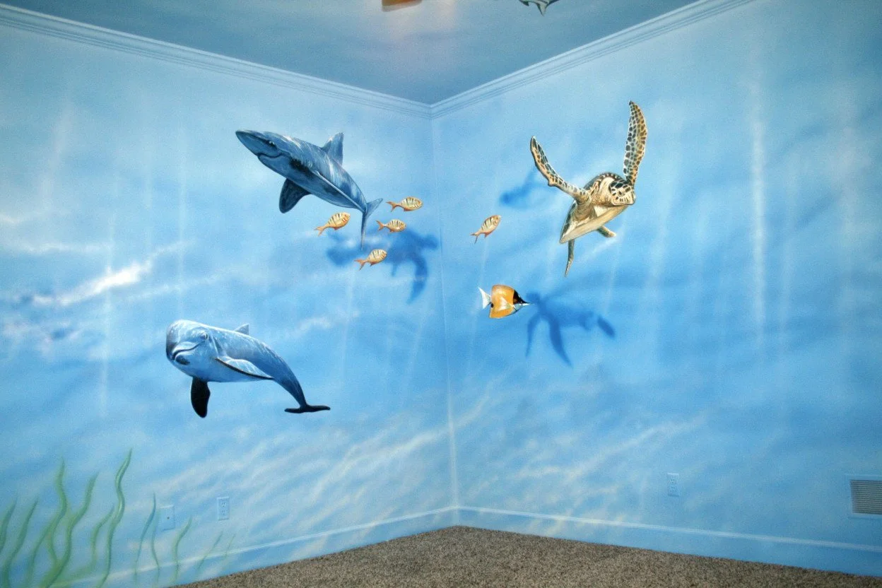 3D wall mural of an underwater scene with a whale, a dolphin, a striped turtle, a clownfish, and small fish, with ocean floor plants in the corner.