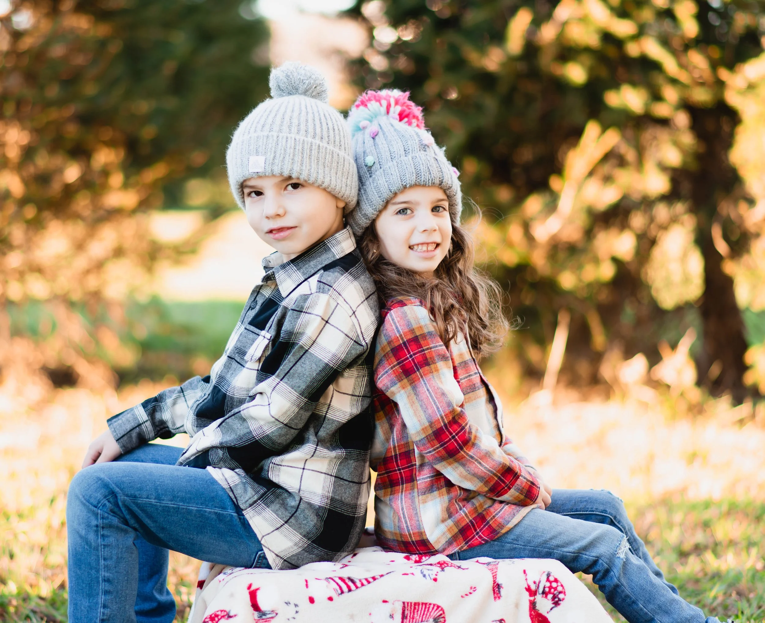 Brother and sister sitting together during an outdoor fall family photography session