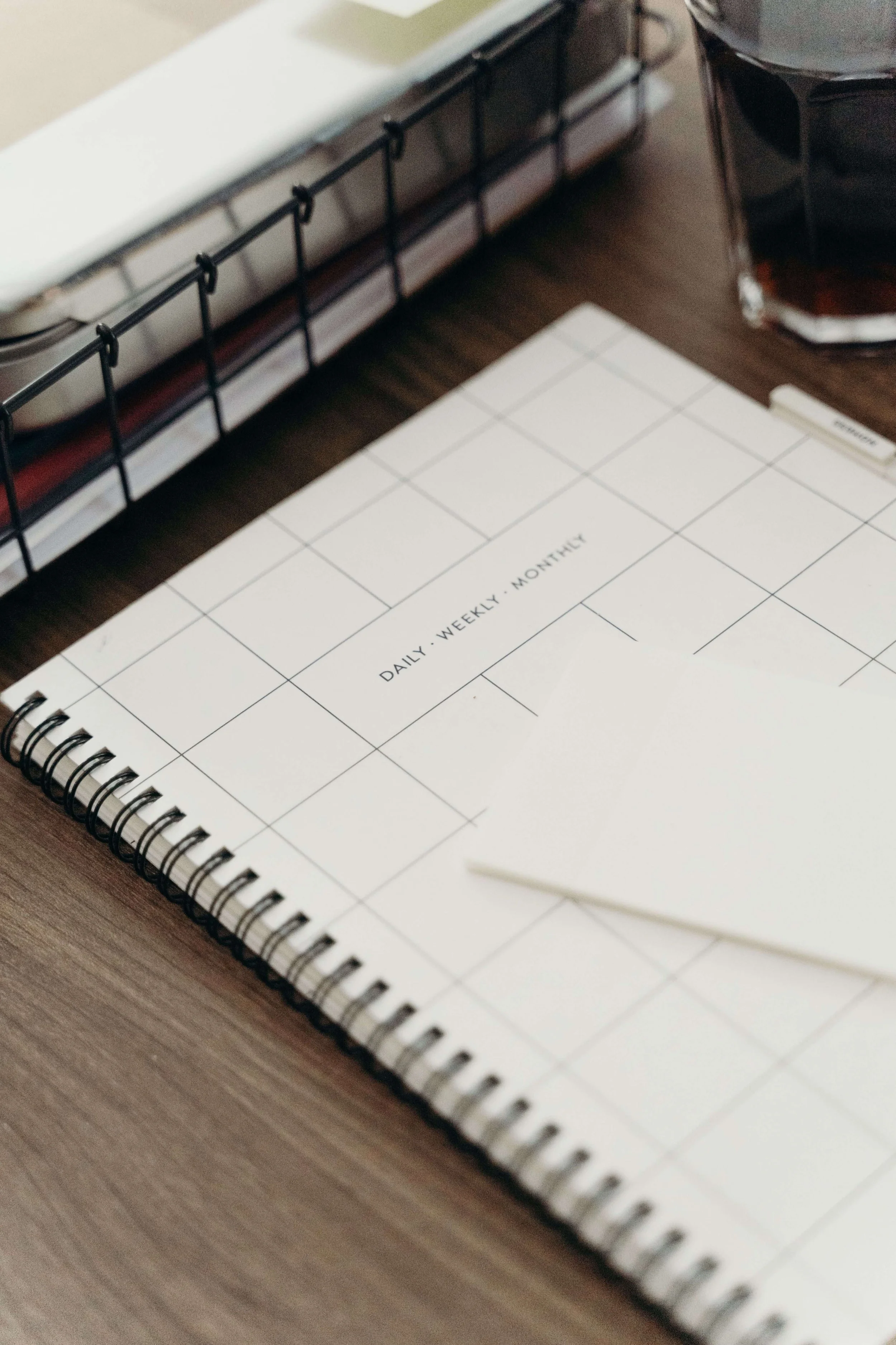 Spiral daily, weekly, monthly planner on a desk, setting the tone for the about page FAQ section.