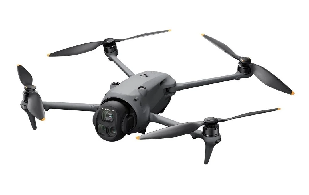 A black quadcopter drone with four rotors and a camera mounted underneath, shown against a white background. DJI Mavic 4 Pro is part of the fleet of drones that Regolith Drones uses for its services.